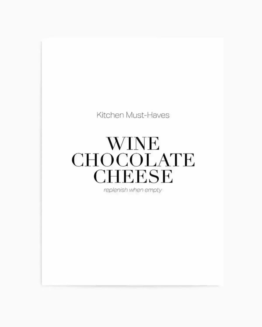 Art print with minimalist design on white background featuring "Kitchen Must-Haves" in small gray sans-serif text at top, followed by "WINE CHOCOLATE CHEESE" in large black serif typography centered on page, with "replenish when empty" in small gray italicized text below. Clean, modern aesthetic with generous white space. Unframed print shown as product shot.