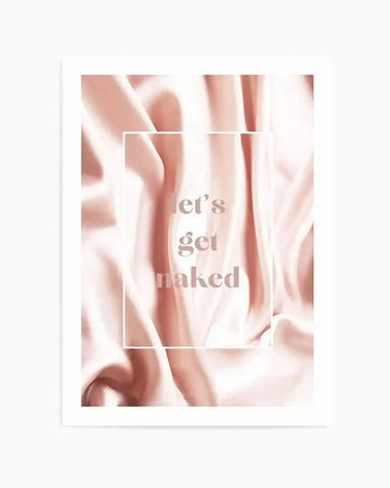 Art print featuring flowing, draped fabric in soft blush pink and cream tones, creating a luxurious, silky texture. The text "let's get naked" is centrally placed in a light pink serif font, enclosed within a thin white rectangular border.