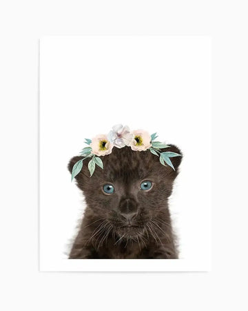 Watercolour art print featuring a close-up of a black leopard cub with bright blue eyes, wearing a delicate flower crown with pale pink and white blossoms and soft green leaves, against a stark white background.