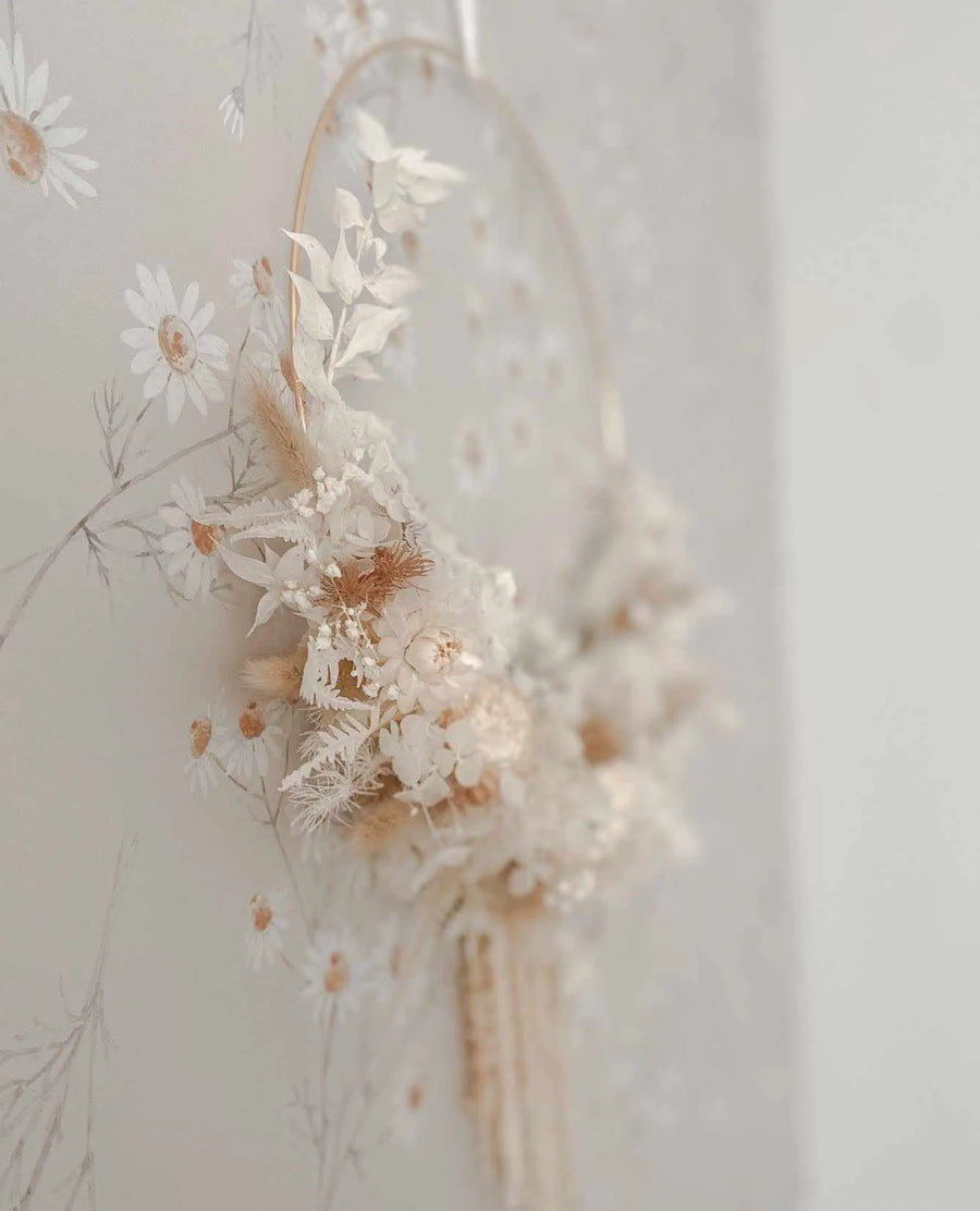 "Peel and stick wallpaper featuring a repeating pattern of hand-painted daisy flowers with white petals and warm brown centers, set against a soft, light grey background. The delicate botanical design has a loose, organic quality with subtle brushstroke texture, creating a gentle and airy aesthetic."