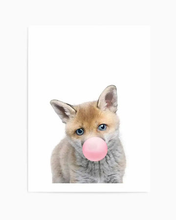 "Art print featuring a close-up photograph of a baby fox with bright blue eyes and soft, fluffy fur in shades of light brown and grey, blowing a vibrant pink bubble gum bubble. The fox is centered on a clean white background, looking directly at the viewer with a slightly tilted head."