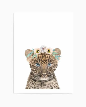 Watercolour art print featuring a baby leopard cub with bright blue eyes and a gentle expression, wearing a delicate flower crown with soft pink, cream, and white blooms and sage green leaves, on a clean white background.
