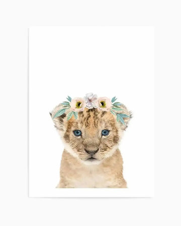 Watercolour art print featuring a cute baby lion cub with bright blue eyes and a small pink and white flower crown with green leaves on its head, set against a plain white background.