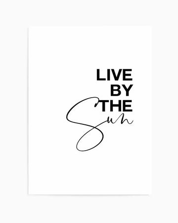 Art print featuring the phrase "LIVE BY THE SUN" in bold black sans-serif capital letters, with "Sun" written in a flowing, elegant script font, all on a clean white background.