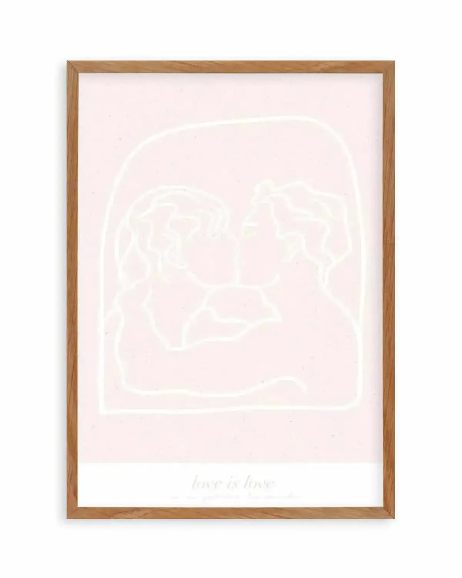 Art print featuring a minimalist line drawing of two figures kissing, outlined in white against a pale pink background, with the text "love is love" in white at the bottom. The print is displayed in a natural oak frame with a white border.