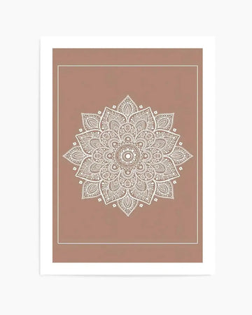Mandala art print featuring an intricate white line-drawn mandala design centered on a warm sienna brown background. The symmetrical mandala contains elaborate geometric and floral patterns radiating from a central circle, with detailed petals and ornamental elements throughout. The design is framed by a thin white border on a larger sienna brown mat. The overall composition creates a balanced, meditative aesthetic with fine linework against the warm, muted background.
