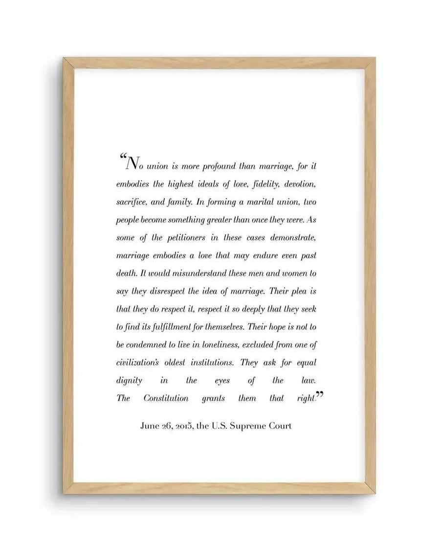 "Framed art print featuring a quote from the US Supreme Court decision on marriage equality, printed in black serif font on a white background, displayed in a natural oak frame with white border. The quote begins: 'No union is more profound than marriage, for it embodies the highest ideals of love, fidelity, devotion, sacrifice, and family.'"
