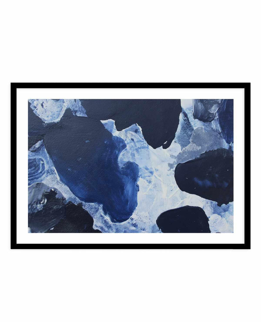 Framed art print titled "Midnight Current I" featuring an abstract aerial composition of deep navy blue and white swirling patterns resembling ocean currents or ice formations. The painted design shows organic, flowing shapes with lighter cream and pale blue accents contrasting against dark navy backgrounds, creating depth and movement. The artwork is displayed in a black frame with a white border.