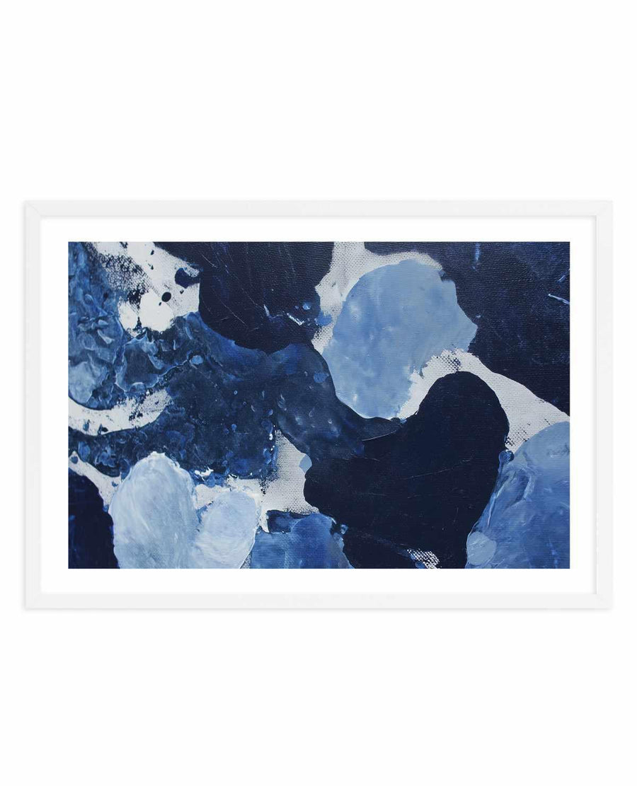 Framed art print titled "Midnight Current II" featuring an abstract painting with swirling brushstrokes in deep navy, midnight blue, and black tones, accented with light blue and white organic shapes that suggest flowing water or currents. The composition has a dynamic, gestural quality with layered paint creating depth and movement. The artwork is displayed in a white frame with white border against a neutral background.