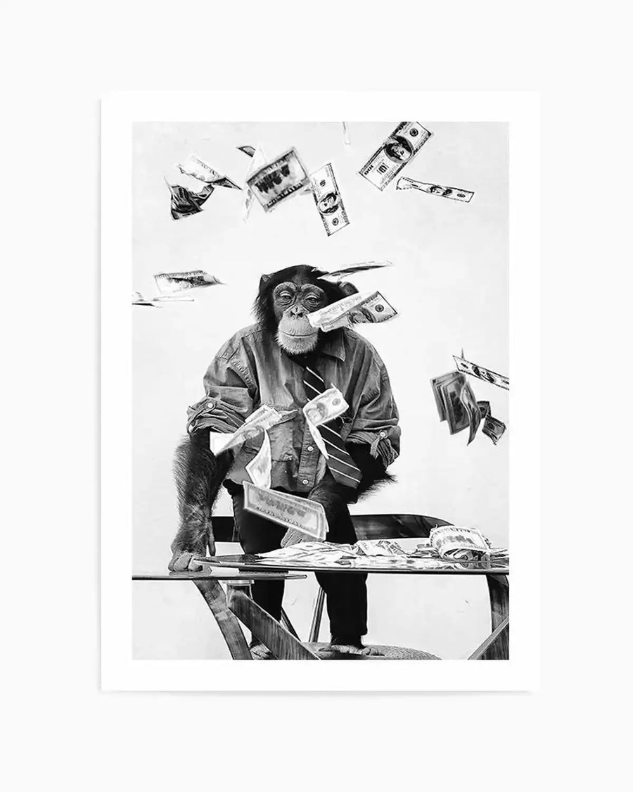"Black and white art print featuring a chimpanzee in a collared shirt and striped tie, sitting at a glass desk with money falling around him. The chimpanzee looks directly forward, with a dollar bill tucked into his mouth, and more bills scattered on the desk in front of him. The composition captures a playful, slightly chaotic scene with a clean white background."