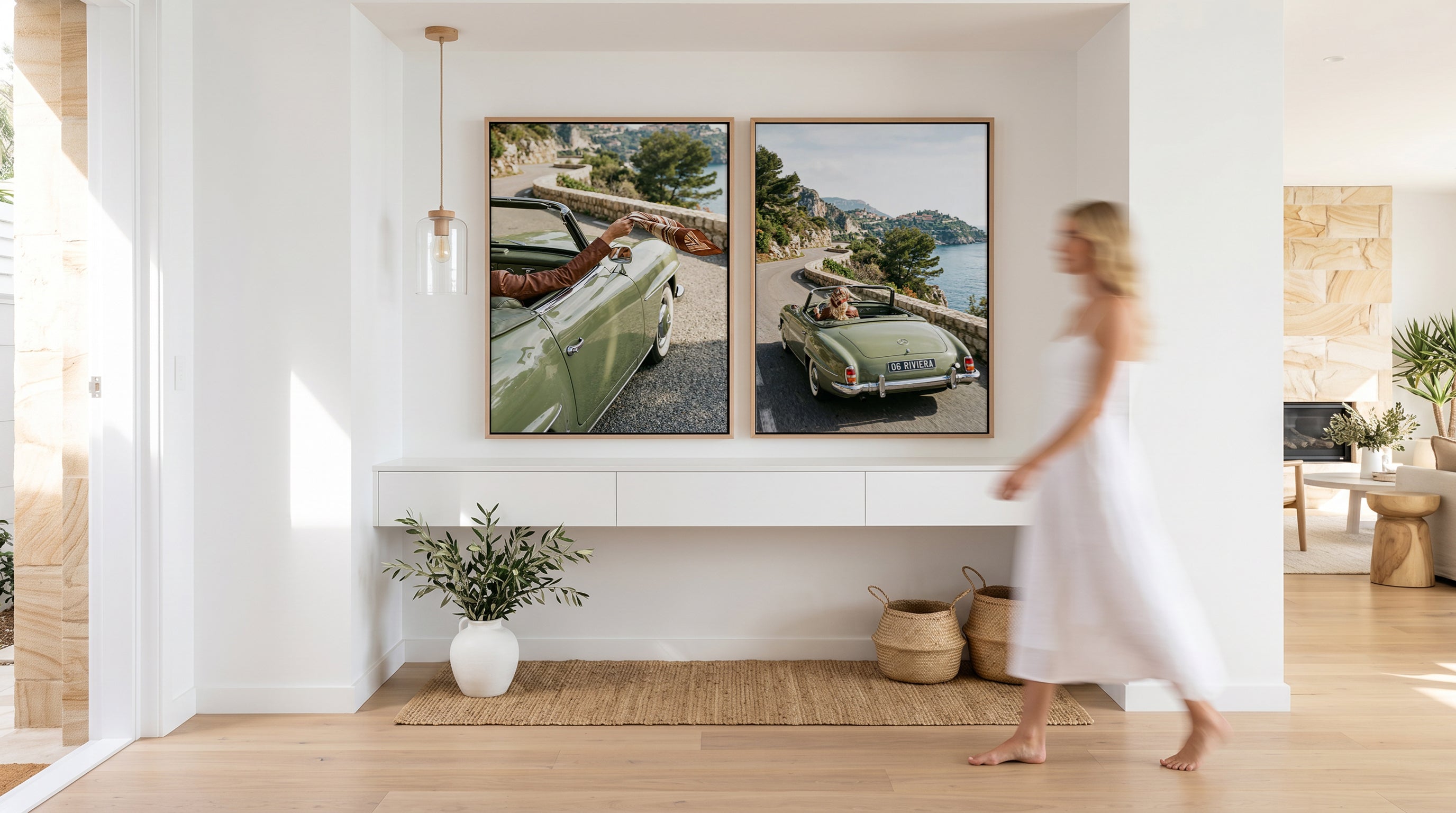 Wall Art Australia by Olive et Oriel - Premium designer wall art online. Two extra large wall art pieces in a living room above a white console, a well lit space and a model wearing a white dress walking past.