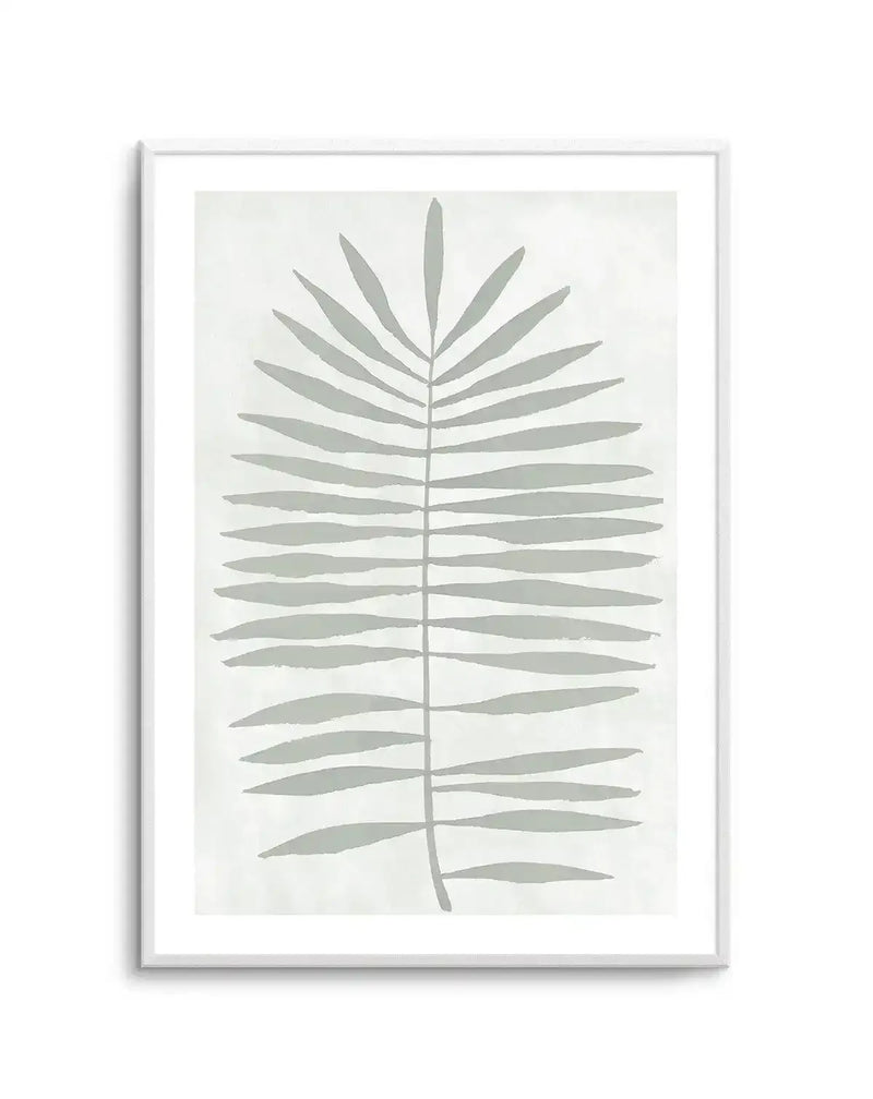 Art print featuring a single palm frond in a minimalist style, with broad, hand-painted sage green leaves extending from a central stem on a soft white background, displayed in a white frame with white border.