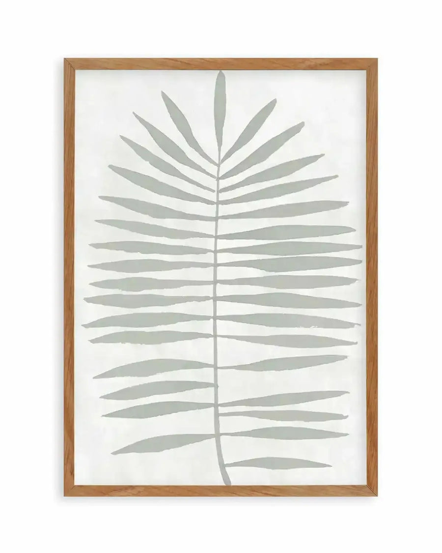 Watercolour art print featuring a single palm frond in a muted sage green against a soft white background, printed on fine art paper and displayed in a natural oak frame with white border.