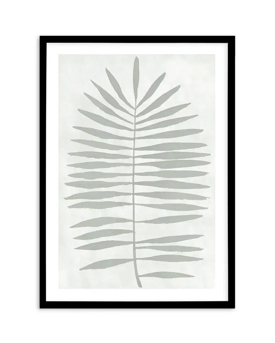 Art print featuring a minimalist illustration of a single palm frond in a muted sage green against a soft white background, with a black frame and white border. The frond is depicted with a central stem and numerous elongated, narrow leaves extending outwards.