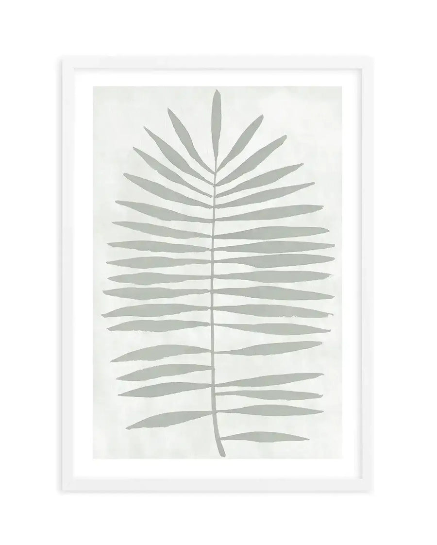 Art print featuring a single, large palm frond illustration in a muted sage green against a soft white background, with a white frame and white border. The frond has a central stem with numerous narrow, elongated leaves extending outwards.