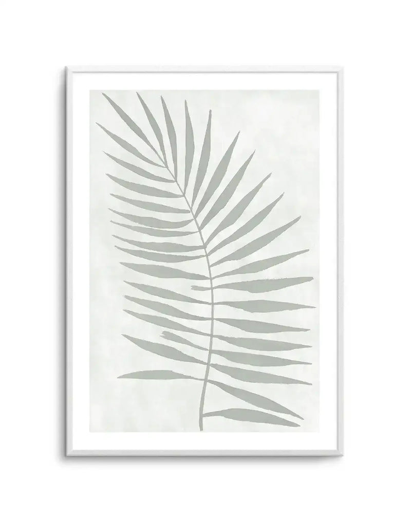Watercolour art print featuring a single palm frond in a muted sage green against a soft white background with subtle texture, displayed in a white frame with white border.