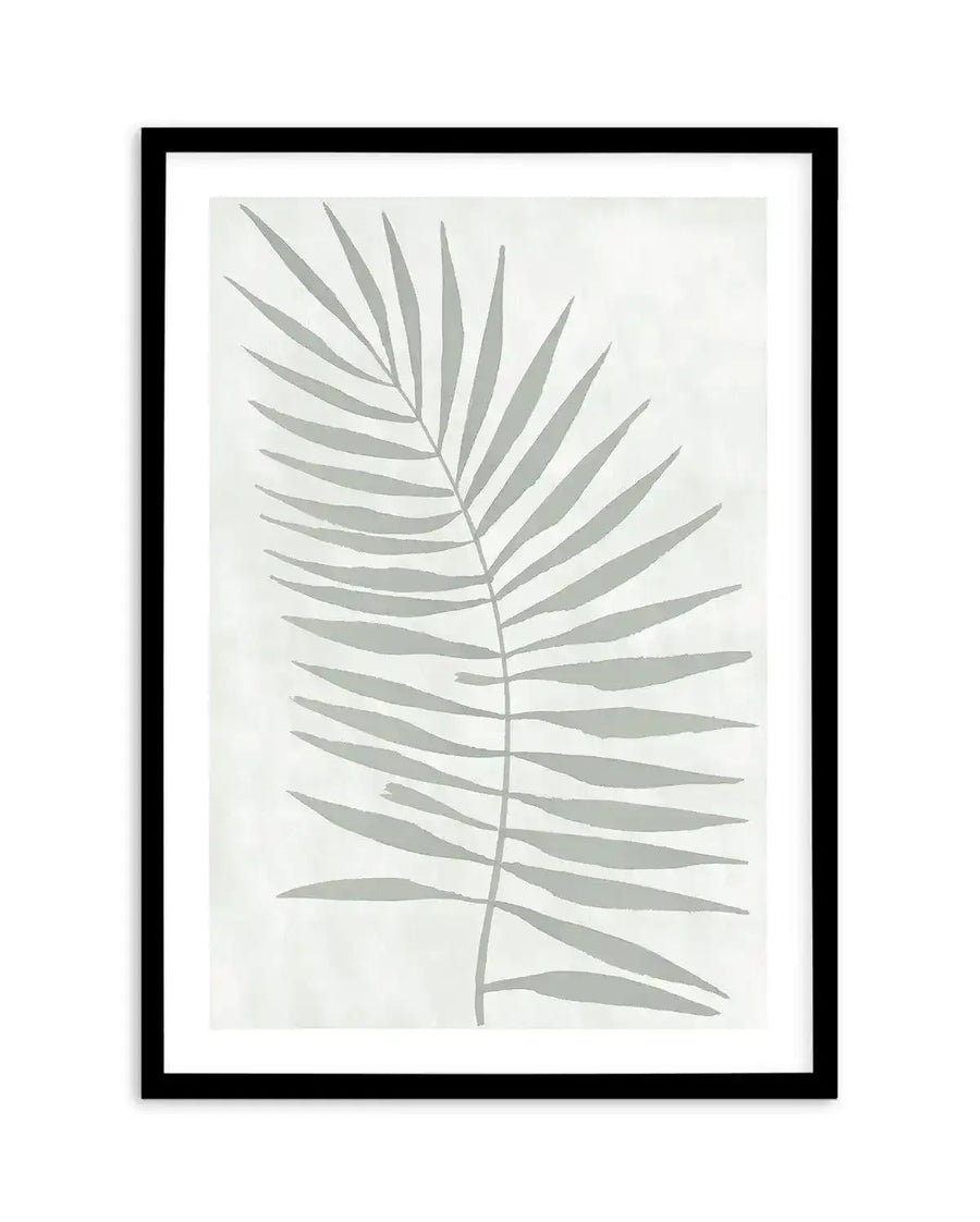 Art print featuring a single palm frond illustration in a muted sage green against a textured off-white background, printed on fine art paper and displayed in a black frame with white border.