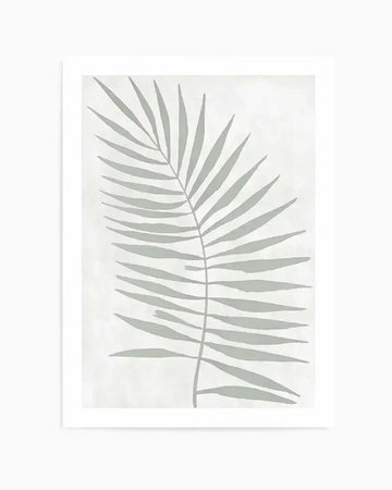 Art print featuring a single palm frond illustration in a muted sage green against a textured off-white background. The frond has a central stem with numerous slender, pointed leaves extending outwards, depicted with a soft, hand-painted quality.