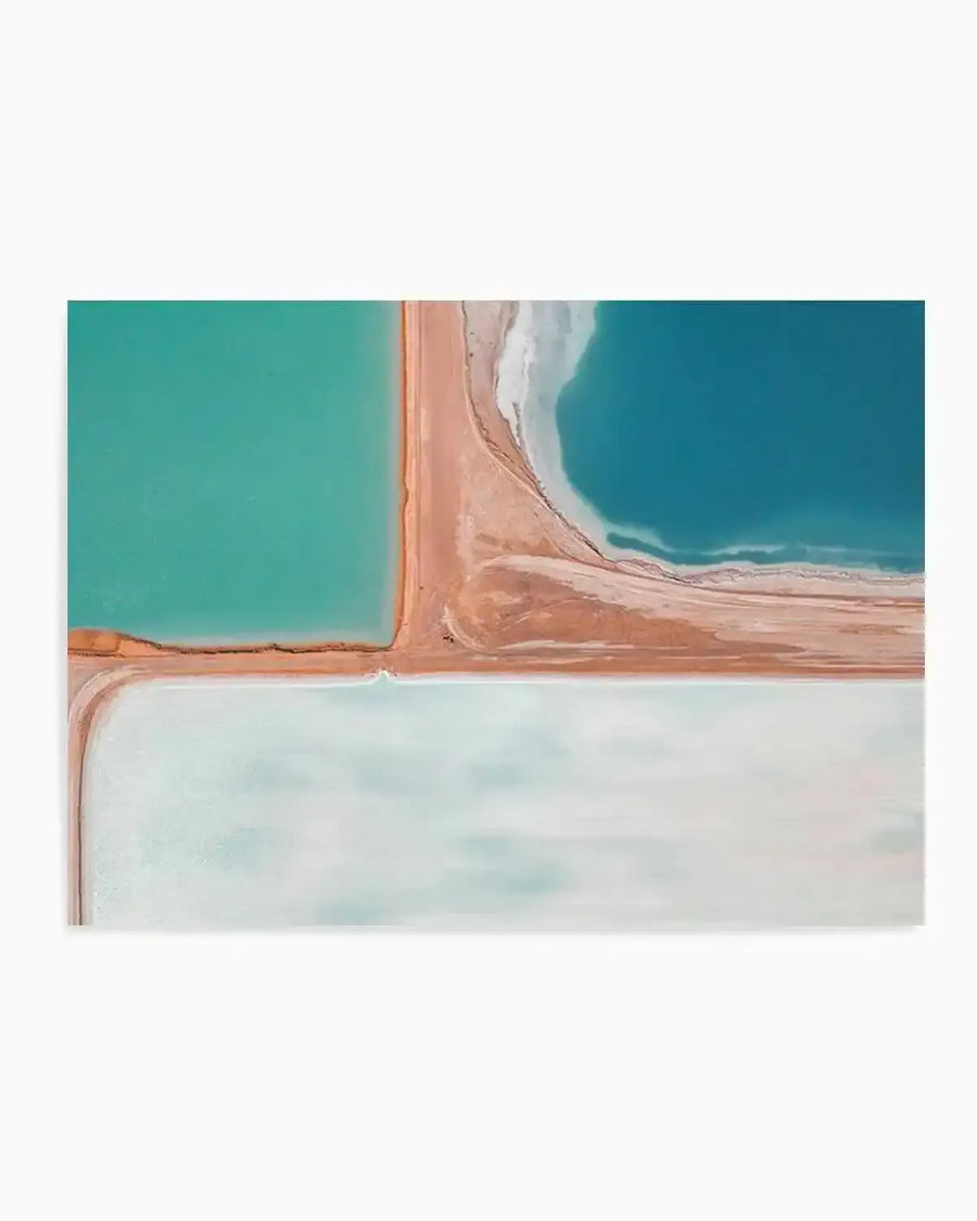 Aerial photography art print of salt fields with distinct sections of vibrant teal, deep turquoise, and pale mint green water, separated by earthy terracotta and sandy beige land formations. The composition highlights the stark contrast and geometric patterns created by the different water and land colours.