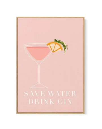 Framed canvas art print featuring a minimalist illustration on a blush pink background. A martini glass with pink liquid is centered in the composition, garnished with an orange slice and fresh rosemary sprig. Below the glass, white sans-serif text reads "SAVE WATER DRINK GIN." The artwork has a clean, line-drawn style with a modern aesthetic. The canvas is set in a natural wood frame with a white border.