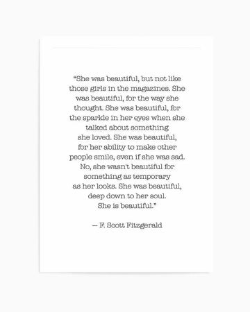 Art print featuring a centered typewritten-style quote by F. Scott Fitzgerald on cream-colored background. The black text reads "She was beautiful, but not like those girls in the magazines..." continuing through "She is beautiful." The quote discusses inner beauty and character rather than physical appearance. Simple, minimalist design with generous white space surrounding the text. The print has a clean, literary aesthetic with serif typeface reminiscent of vintage typewriter typography.