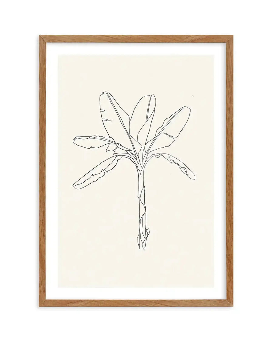 Line art print featuring a minimalist black outline drawing of a banana palm tree with large leaves and a textured trunk, on a cream background, displayed in a natural oak frame with white border.