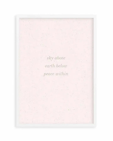 Art print featuring the words "sky above earth below peace within" in a delicate, light grey serif font on a pale pink background with subtle speckle texture, displayed in a white frame with a white border.