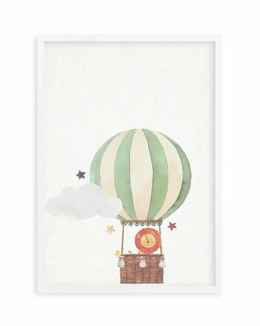 Watercolour art print featuring a whimsical hot air balloon with cream and sage green stripes, carrying a smiling lion in a wicker basket. The scene includes a white cloud and scattered stars in blue, red, and yellow on a textured white background, displayed in a white frame with a white border.