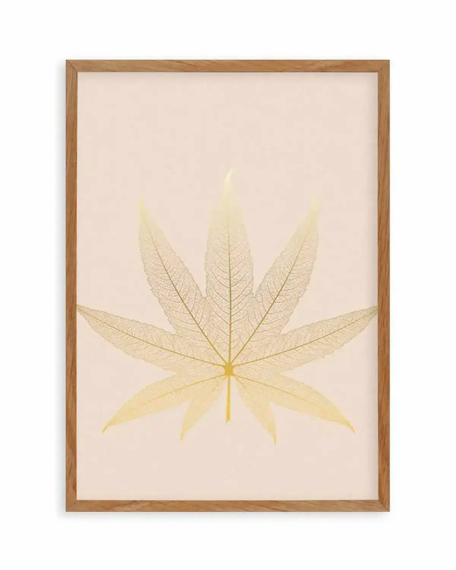Art print featuring a detailed skeleton leaf in a pale golden yellow hue against a soft cream background, printed on fine art paper and displayed in a natural oak frame with white border. The leaf has seven lobes, fanning out from a central stem, with intricate vein patterns visible throughout.