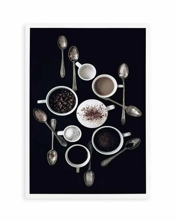 Overhead photography art print featuring an arrangement of coffee-related items on a dark, almost black background. The composition includes several white ceramic cups and mugs, some containing coffee beans, ground coffee, a milky beverage, or sugar. Various antique-looking silver spoons are scattered among the items, some resting in cups or crossing over each other, creating a rustic and inviting still life.
