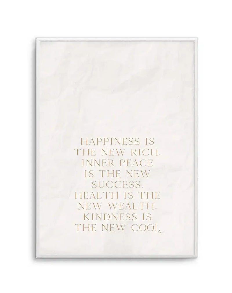Art print featuring the quote "HAPPINESS IS THE NEW RICH. INNER PEACE IS THE NEW SUCCESS. HEALTH IS THE NEW WEALTH. KINDNESS IS THE NEW COOL." in a light gold, serif font on a textured, off-white background, displayed in a white frame with a white border.