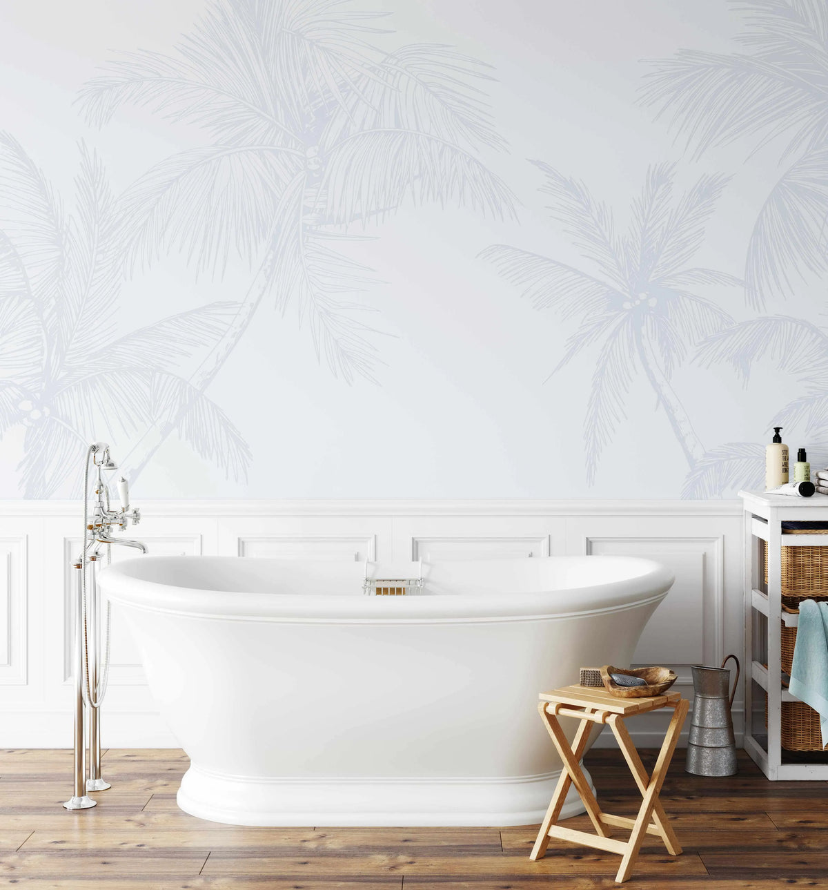 The Palms Wallpaper in Duck Egg Blue displayed on a bathroom wall above white wainscoting. The wallpaper features delicate, feathery palm fronds in soft periwinkle blue and gray tones rendered in a linear, sketched illustration style against a pale cream background. The design creates an airy, botanical aesthetic. The wallpaper is shown in a luxurious bathroom setting with a freestanding white soaking tub, wooden flooring, chrome fixtures, and natural light illuminating the subtle pattern.