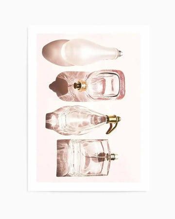 Photography art print featuring four perfume bottles lying horizontally on a pale pink background, casting long shadows. The top bottle is frosted white and pear-shaped. The second is a clear rectangular bottle with a gold sprayer, filled with pink liquid. The third is a clear, elongated bottle with a gold pump. The bottom bottle is a clear, square bottle with a silver sprayer, filled with pink liquid.