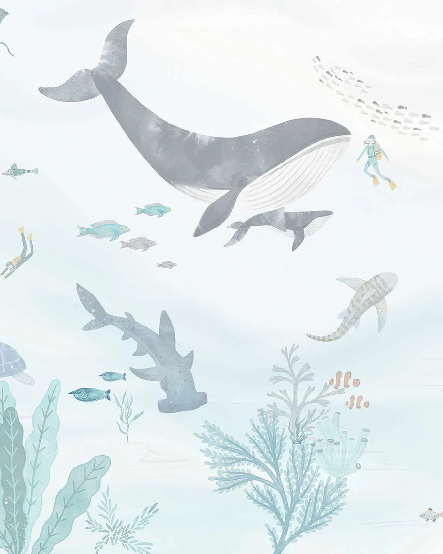 Close-up of pale blue watercolour wallpaper with grey whales, sharks, teal seaweed and scuba diver illustrations