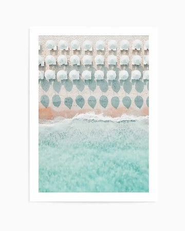 Art print featuring a serene beach scene with rows of white and sage green umbrellas arranged in repeating patterns across sand-colored beach. Turquoise ocean water with white-capped waves fills the lower portion. Soft watercolor aesthetic with muted, pastel tones of cream, mint green, dusty sage, and peachy-tan. White border frames the artwork. Vertical composition with peaceful, tranquil mood evoking a seaside vacation atmosphere.