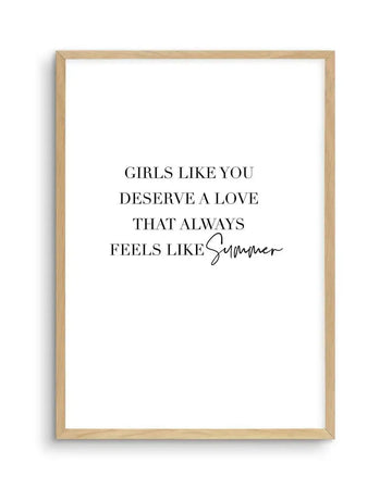 Art print featuring the quote "GIRLS LIKE YOU DESERVE A LOVE THAT ALWAYS FEELS LIKE Summer" in black text, with "Summer" in a handwritten script font, on a crisp white background, displayed in a natural oak frame with white border