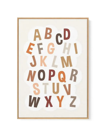 Framed canvas art print featuring the complete alphabet arranged in a cloud-like formation against a cream background. Letters in varying sizes and warm neutral tones including tan, terracotta, rust, chocolate brown, and sage green. Natural wood frame with white border. Suitable for nursery or educational spaces.