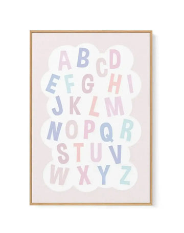 Framed canvas art print featuring the complete alphabet arranged in a cloud shape against a soft beige background. Letters in pastel colors including dusty blue, blush pink, sage green, and pale mauve are scattered throughout the design. Natural wood frame with white border.