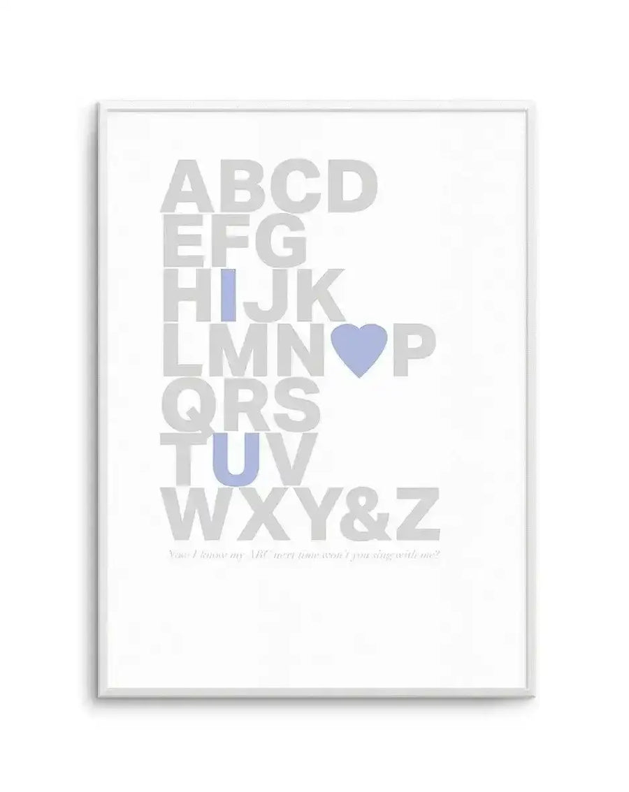 Framed art print featuring the complete alphabet in large, light grey capital letters arranged in a grid pattern. A blue heart replaces the letter O, and the letters I, T, and U are highlighted in soft blue. Small grey text at the bottom reads "Your favourite ABC won't you sing with me?" The design is mounted in a white frame with a white border against a white background.