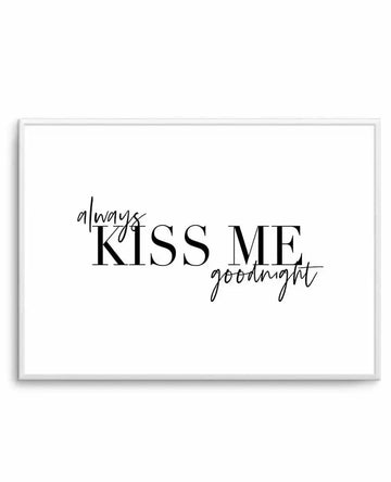 Art print with gray frame displaying black text on white background. The words "always KISS ME goodnight" are arranged across the center, with "KISS ME" in large serif font and "always" and "goodnight" in smaller connected script handwriting style. The minimalist design has a clean, contemporary aesthetic with high contrast black typography on white.