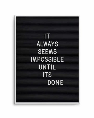 White-framed art print featuring a black letterboard background with white letters displaying the motivational quote "IT ALWAYS SEEMS IMPOSSIBLE UNTIL ITS DONE" in centered, uppercase text. The letterboard has a ribbed texture typical of changeable letter boards. White frame with clean edges completes the minimalist design.