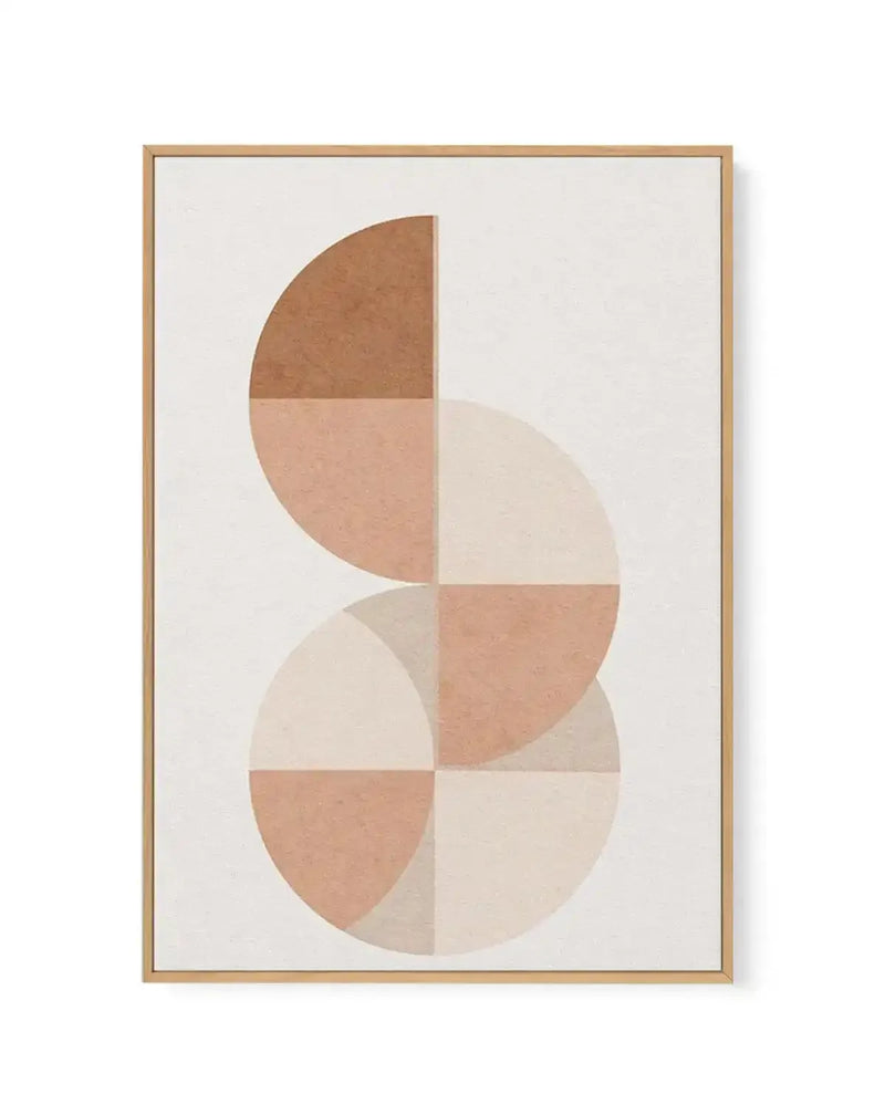 Framed canvas art print titled Arches In Sand II featuring abstract geometric composition. Two overlapping circles divided into quarters, creating four sections each in varying shades of terracotta, tan, cream, and beige. Upper circle rendered in darker brown and lighter peachy tones, lower circle in cream and dusty rose. Matte finish with soft, earthy colour palette against off-white background. Natural wood-tone frame with white border.