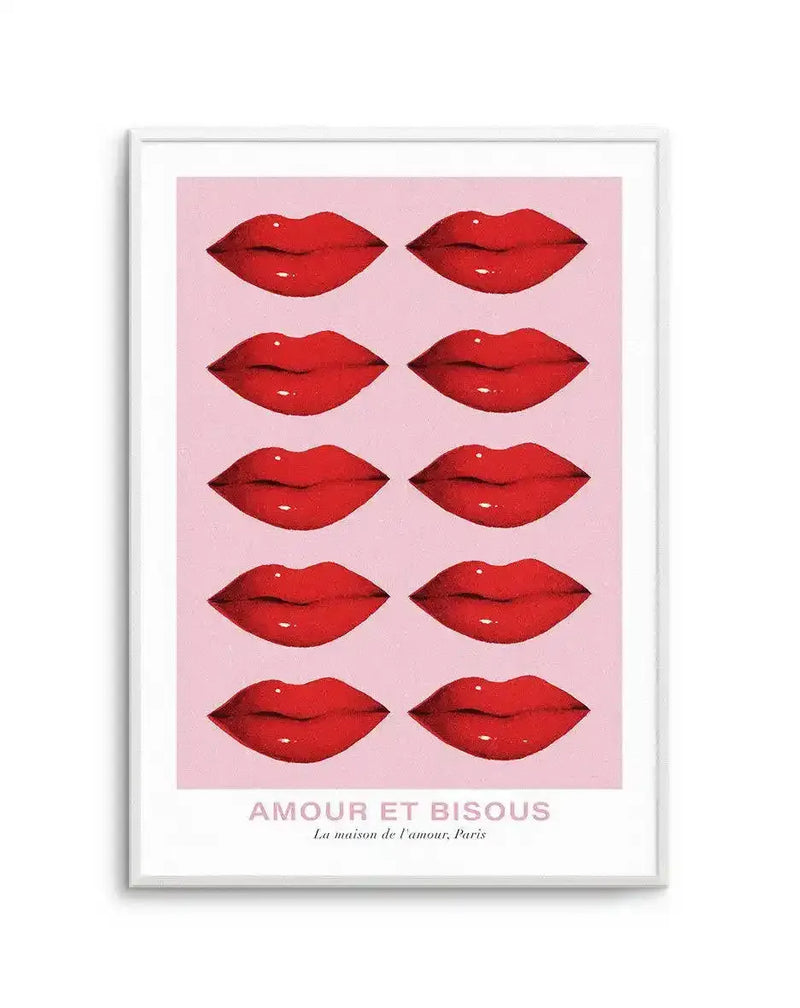 Art print featuring ten pairs of bright red lips with subtle highlights, arranged in five rows of two on a soft pink background, printed on fine art paper and displayed in a white frame with white border. The text at the bottom reads "AMOUR ET BISOUS" and "La maison de l'amour, Paris".