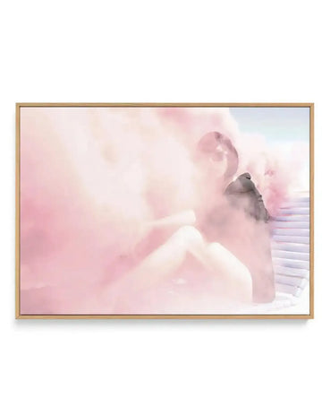 Framed canvas art print featuring a dreamy, soft-focus illustration of a small gray bird perched on a white wooden railing. The composition is dominated by soft pink, blush, and cream tones with wispy, cloud-like brushstrokes creating an ethereal atmosphere. White ornamental swirls float in the background. The canvas is mounted in a natural wood frame with a white border.