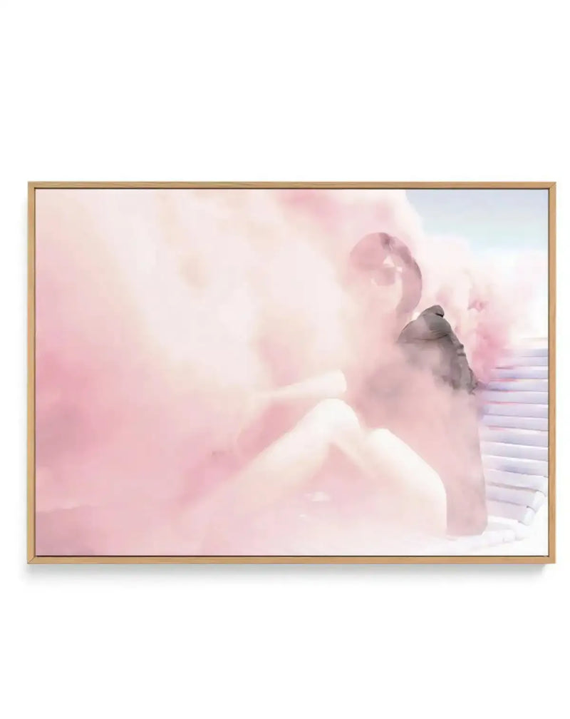 Framed canvas art print featuring a dreamy, soft-focus illustration of a small gray bird perched on a white wooden railing. The composition is dominated by soft pink, blush, and cream tones with wispy, cloud-like brushstrokes creating an ethereal atmosphere. White ornamental swirls float in the background. The canvas is mounted in a natural wood frame with a white border.