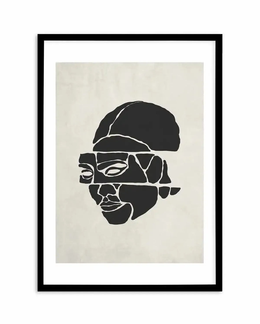 Abstract art print featuring a fragmented face in solid black on a light cream background, displayed in a black frame with a white border. The face is composed of irregular, puzzle-like pieces, with distinct lines forming the eyes, nose, and mouth, creating a deconstructed yet recognizable human form.