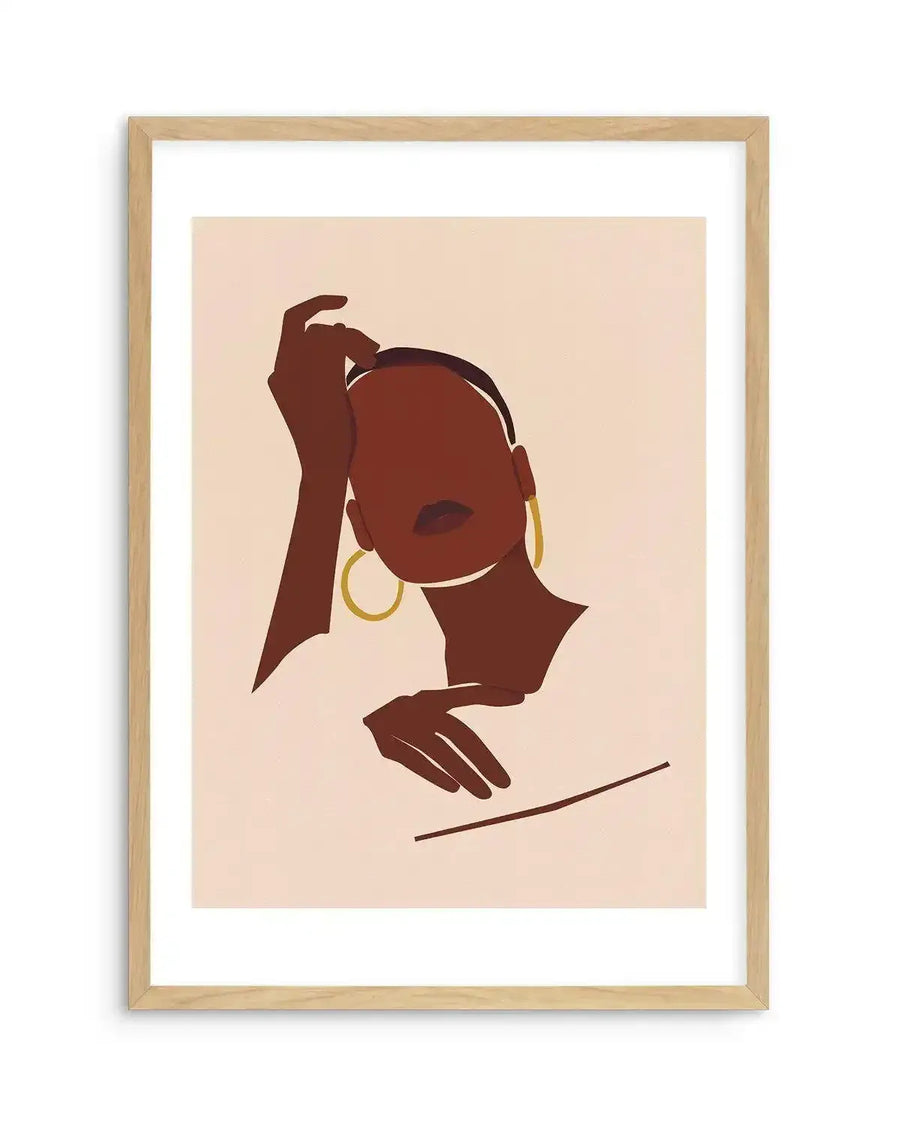 Art print featuring an abstract illustration of a woman with dark brown skin and a minimalist style, displayed in a natural oak frame with white border. The woman's face is turned slightly to the right, with one hand resting on her head and the other hand gently placed below her chin. She wears large gold hoop earrings and has dark lips. The background is a soft, light peach colour.
