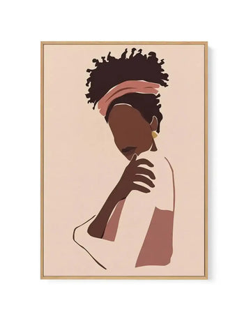 Framed canvas print featuring a minimalist illustration of a woman with dark brown skin and curly black hair, wearing a dusty rose headband and a light-colored top. Her head is tilted down and to the left, with one hand gently touching her chest, and she wears a single gold earring. The background is a soft, pale peach, and the artwork is displayed in a natural oak frame.
