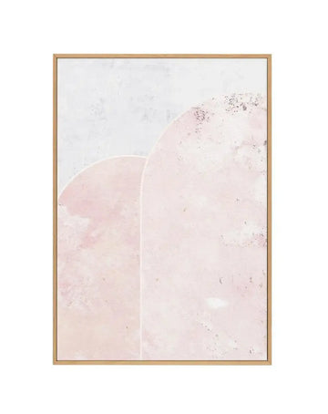 Framed canvas art print featuring two overlapping soft blush pink circular shapes against a light cream background with subtle speckled texture. The composition has a minimalist, organic aesthetic with delicate gradations in tone and fine grainy details throughout. Natural wood-tone frame with thin border, displayed as a vertical rectangular print.
