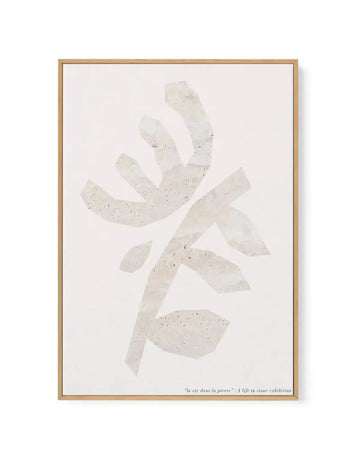 Framed canvas art print featuring an abstract composition of pale cream and beige rectangular shapes with speckled texture arranged in a starburst or pinwheel pattern against a light off-white background. Natural wood frame with white border. Small text at bottom reads "la vie dans la pierre" and "A life in stone exhibition". Vertical orientation.